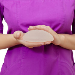 Plastic surgeon presenting a breast implant.